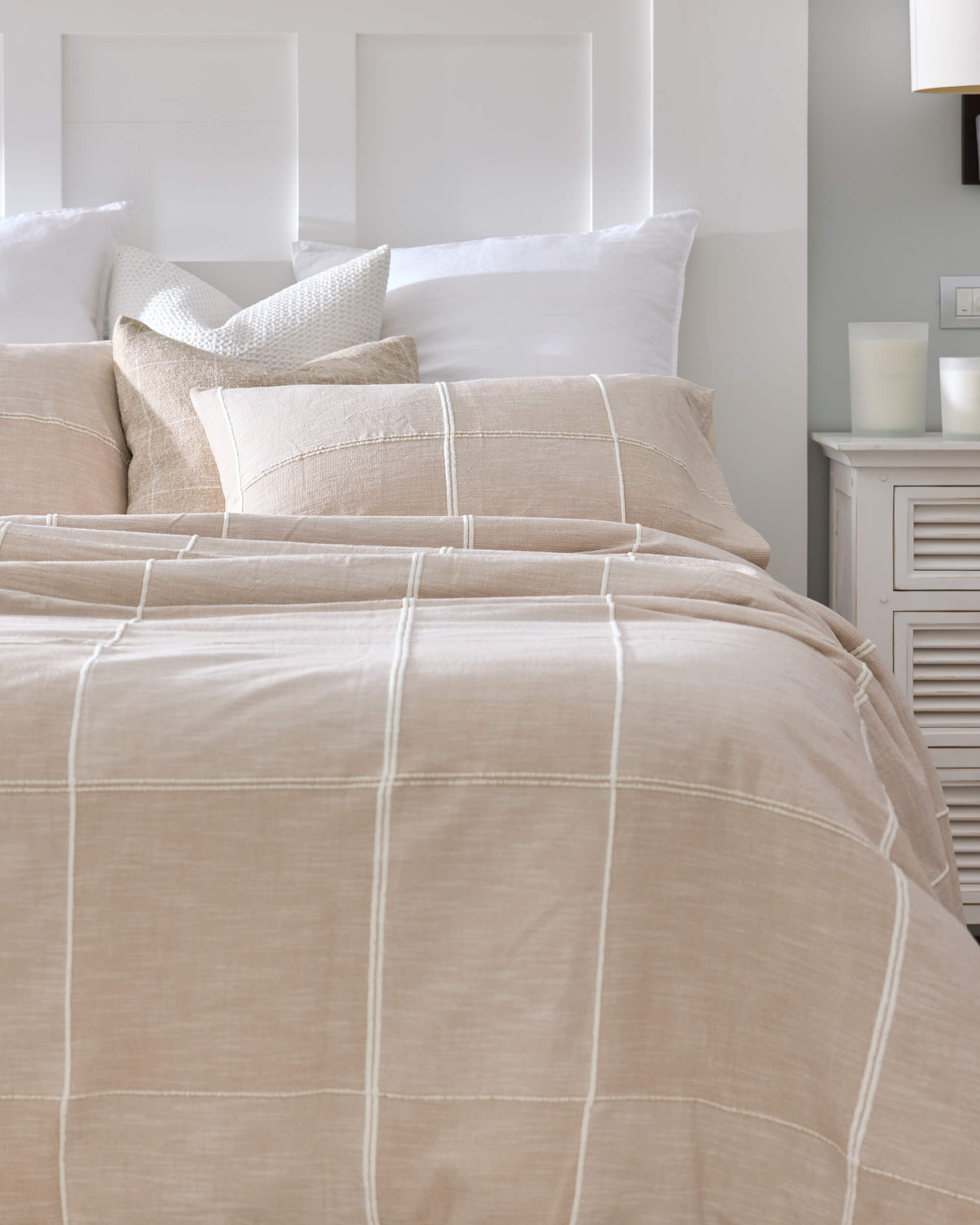 Royal Doulton Whitby neutral grid bedding styled with layered white and textured pillows