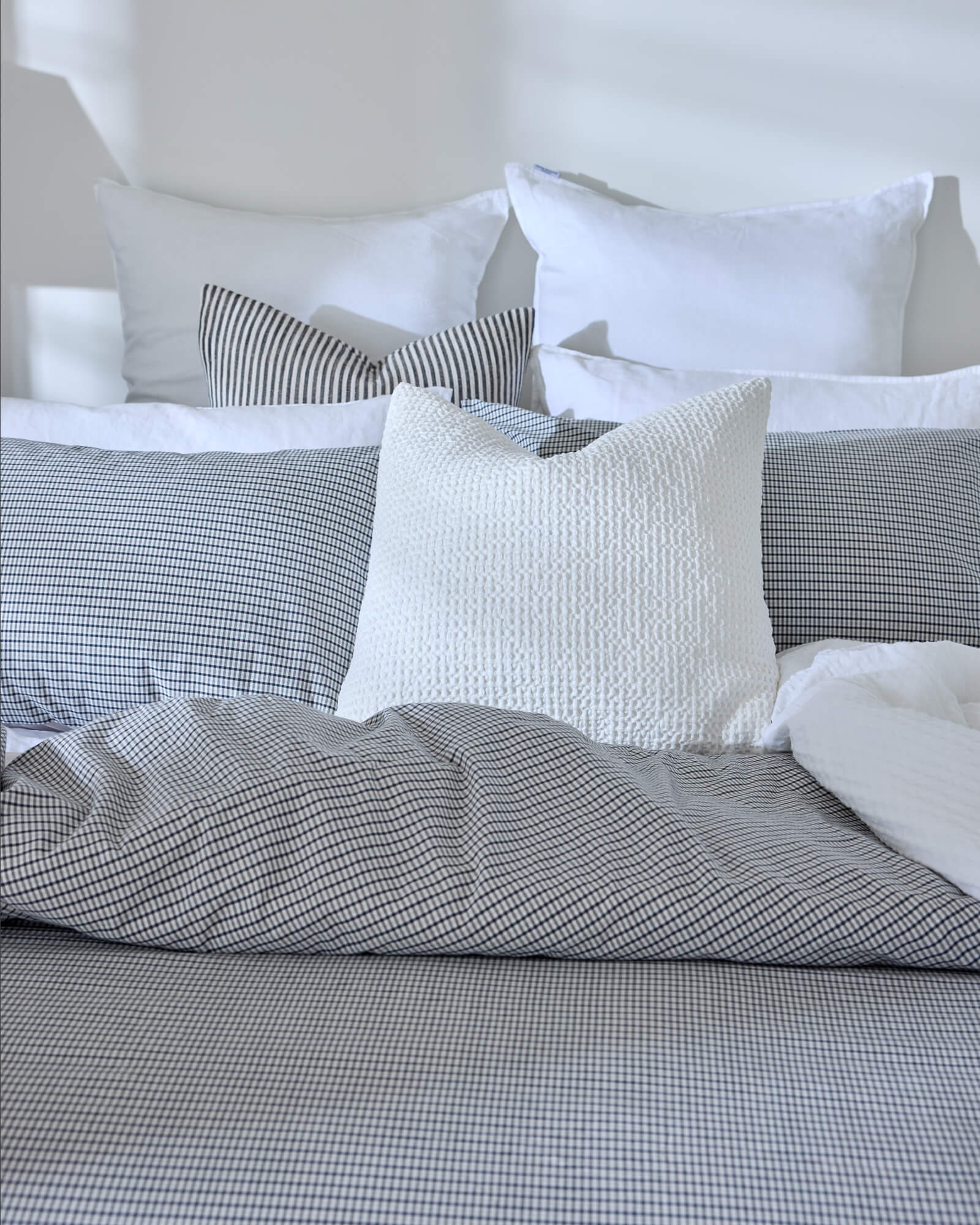 Royal Doulton Kent duvet cover styled on a bed with coordinating Wade duvet cover set, Winslow Snow Cushion​, Montrose Stripe Cushion​, Beaumont Check Cushion​.