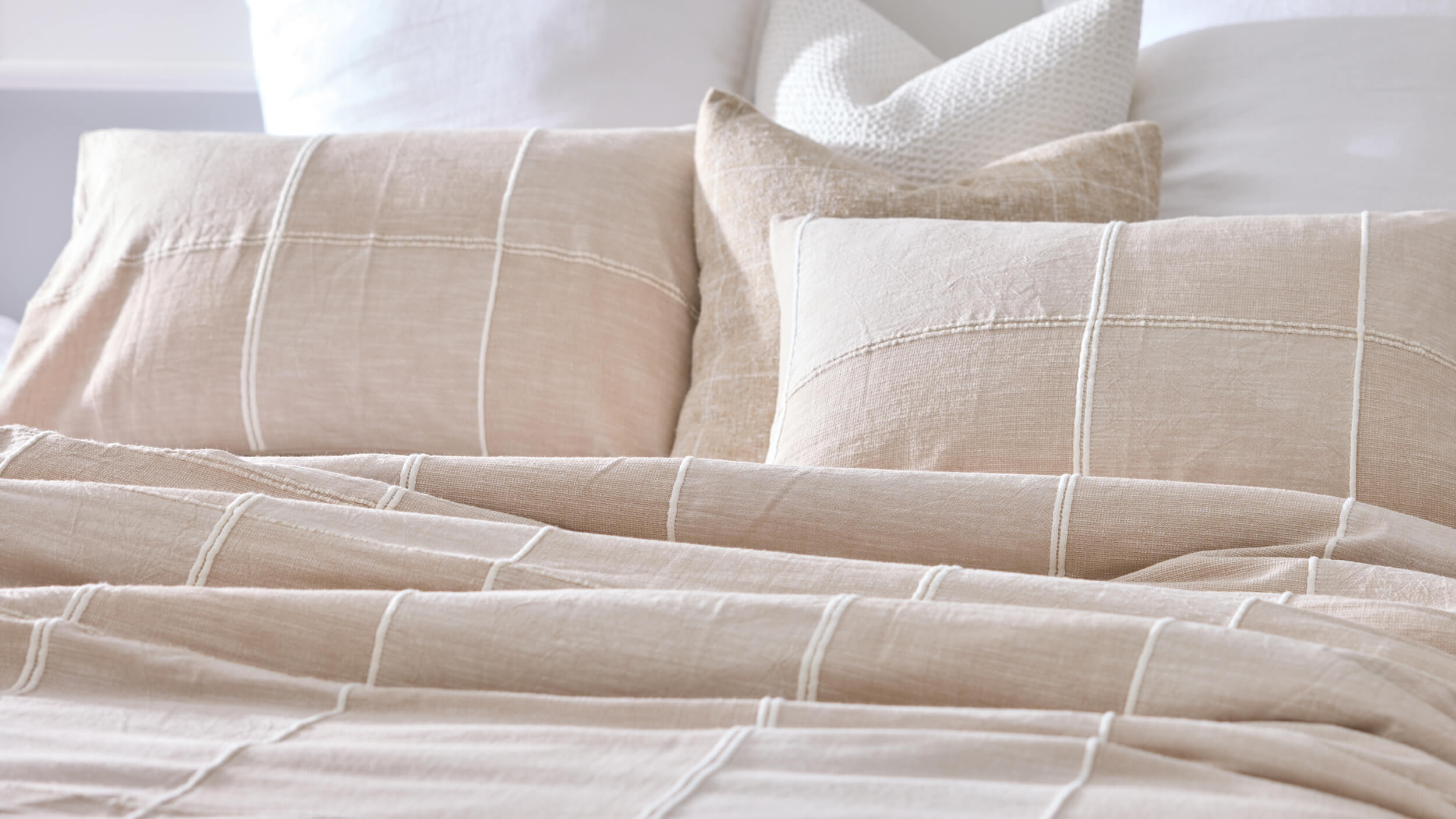 Royal Doulton Whitby neutral checked duvet cover styled with matching pillowcases and white cushions